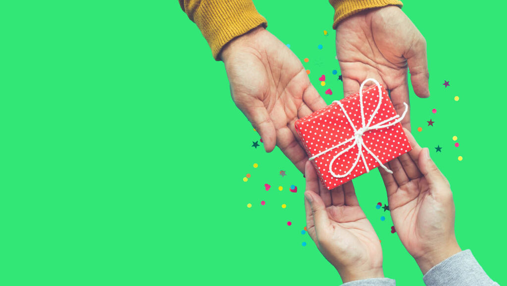 Two pairs of hands holding a small wrapped present