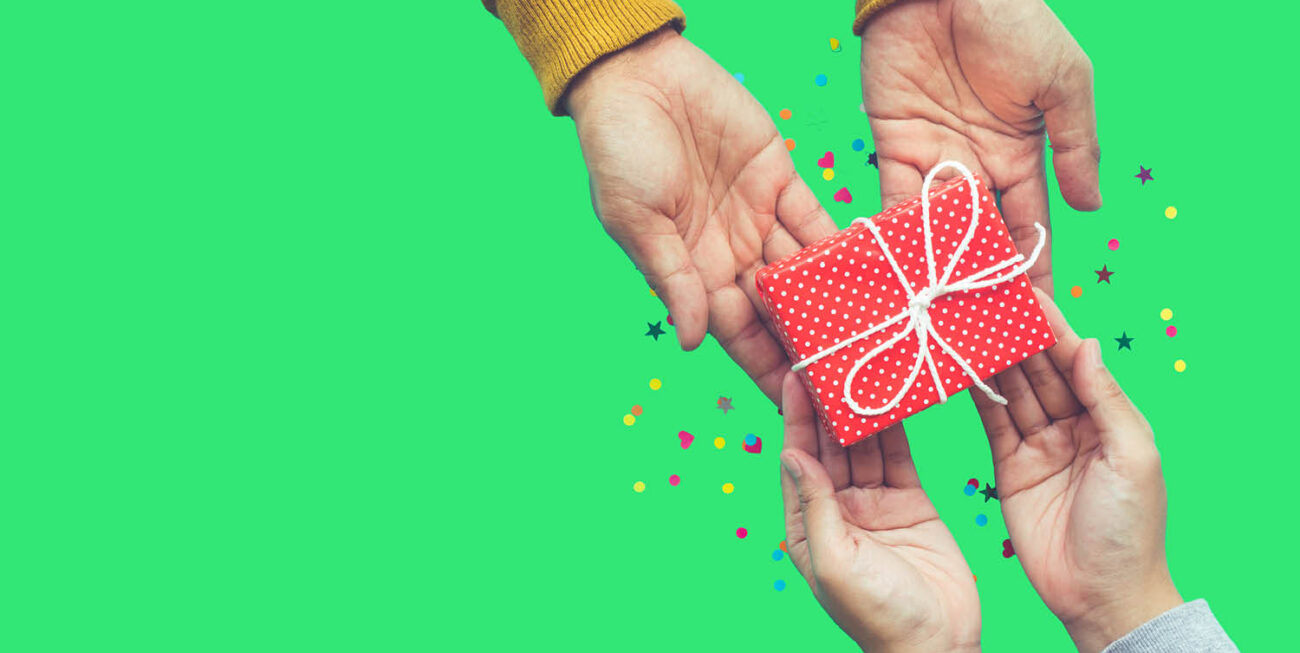 Two pairs of hands holding a small wrapped present