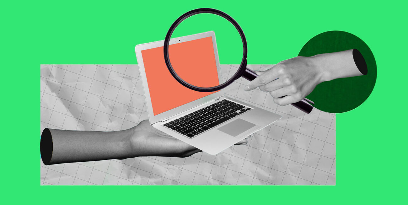 Hands holding a laptop with a magnifying glass