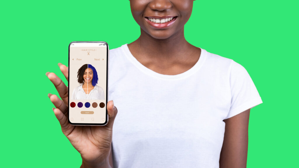 Person holding a phone showing an AR haircut app