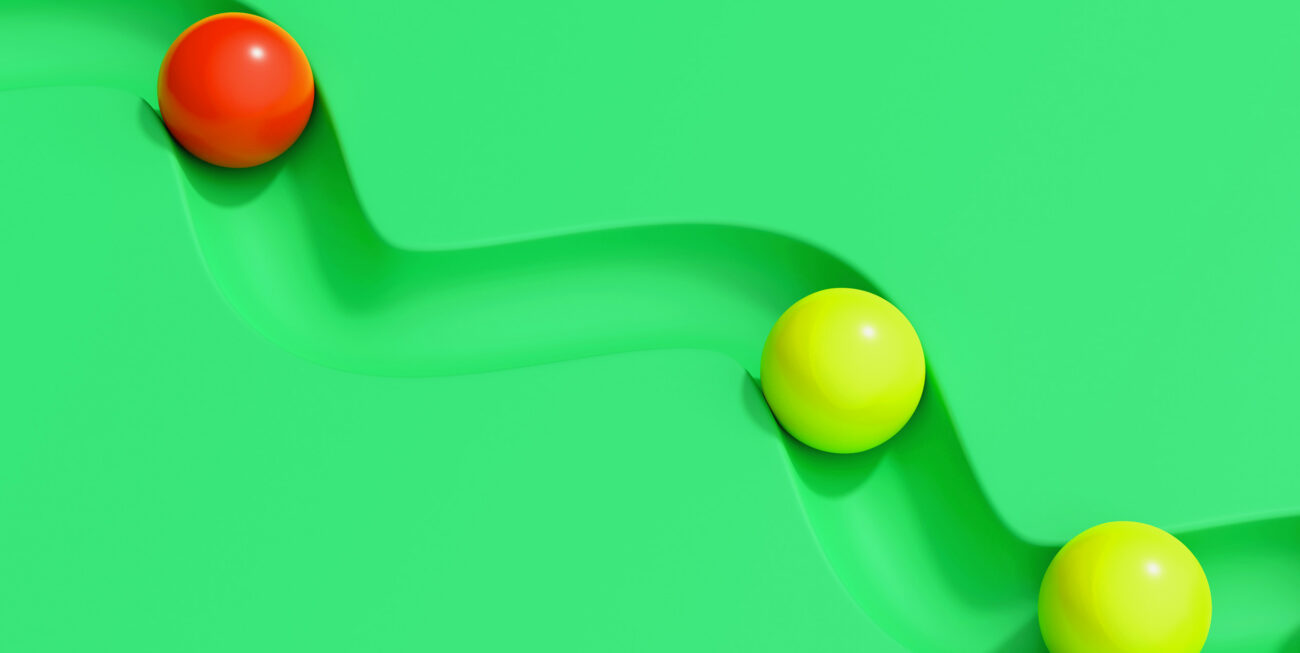 Red and yellow spheres rolling through a track
