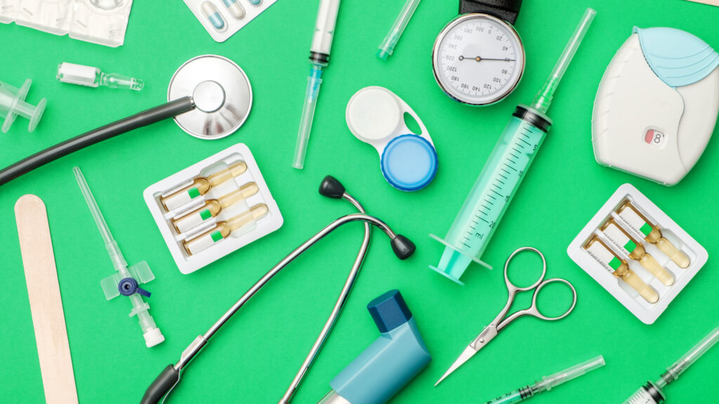 Flat lay of medical tools on colored background. Healthcare insurance concept. Table top view essential doctor's equipment