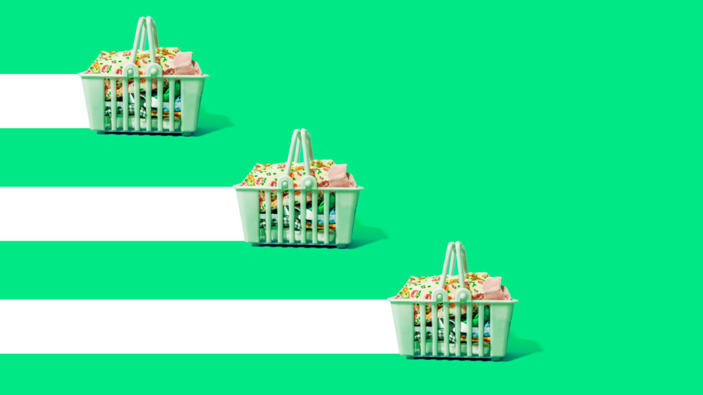 Three green shopping baskets filled with clothing