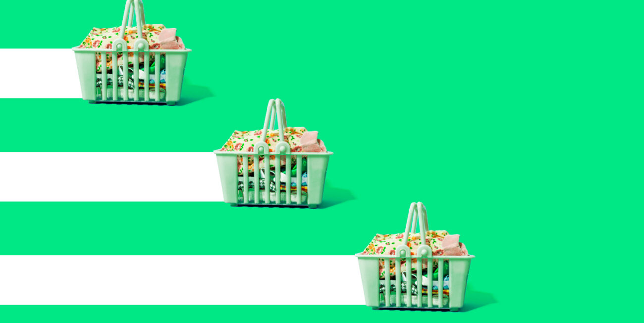 Three green shopping baskets filled with clothing