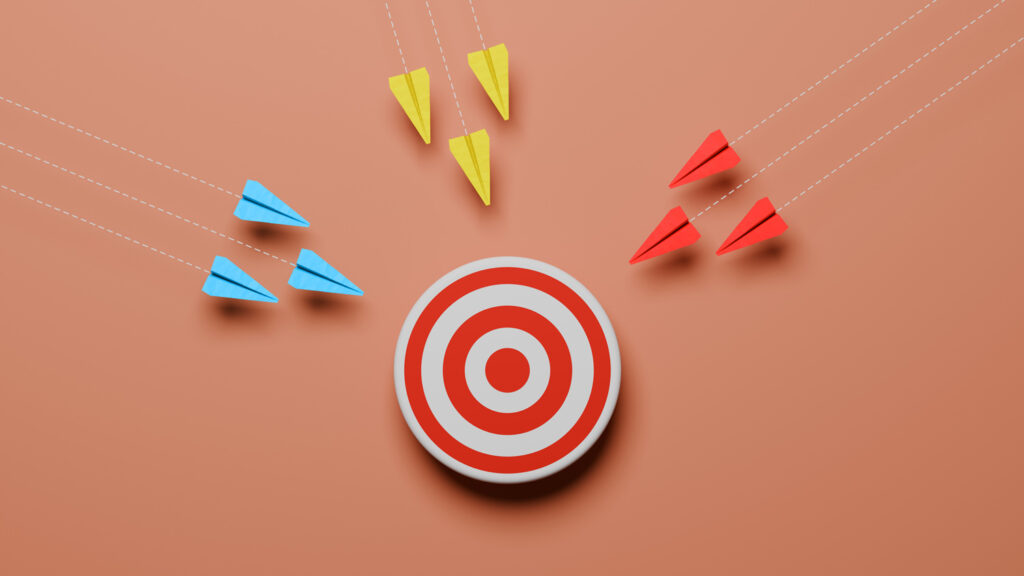 Three groups of paper airplanes flying toward a target