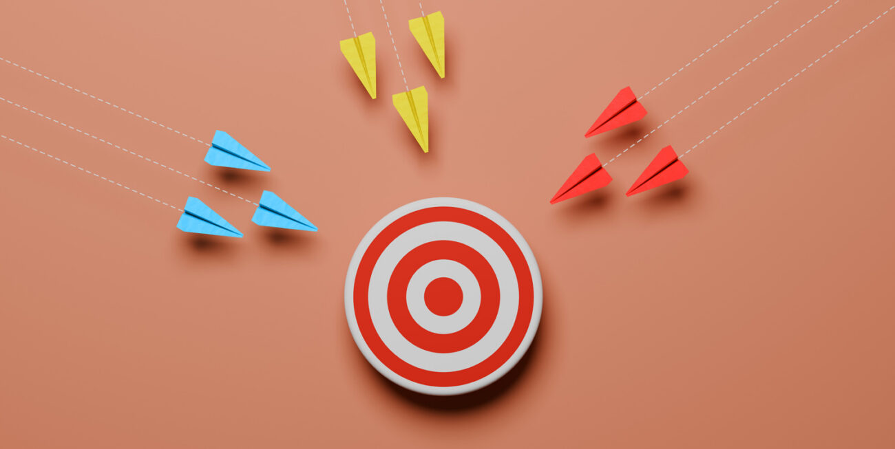 Three groups of paper airplanes flying toward a target