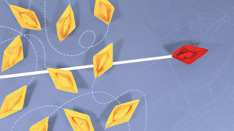 A red paper boat separating itself from the yellow paper boats A red paper boat separating itself from the yellow paper boats