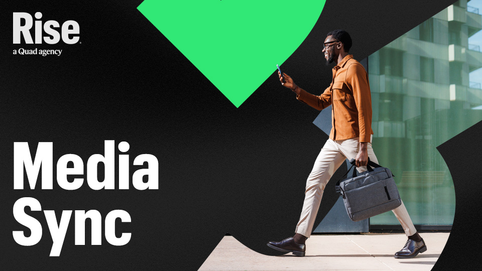 A man walking and looking at their phone. Text reads: Media Sync