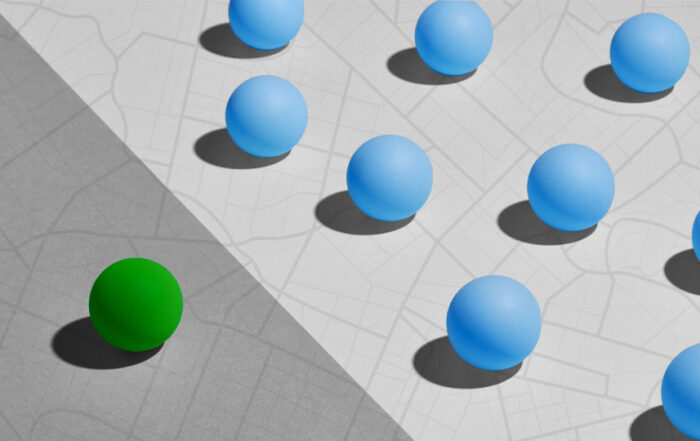 One green globe set apart from many blue globes