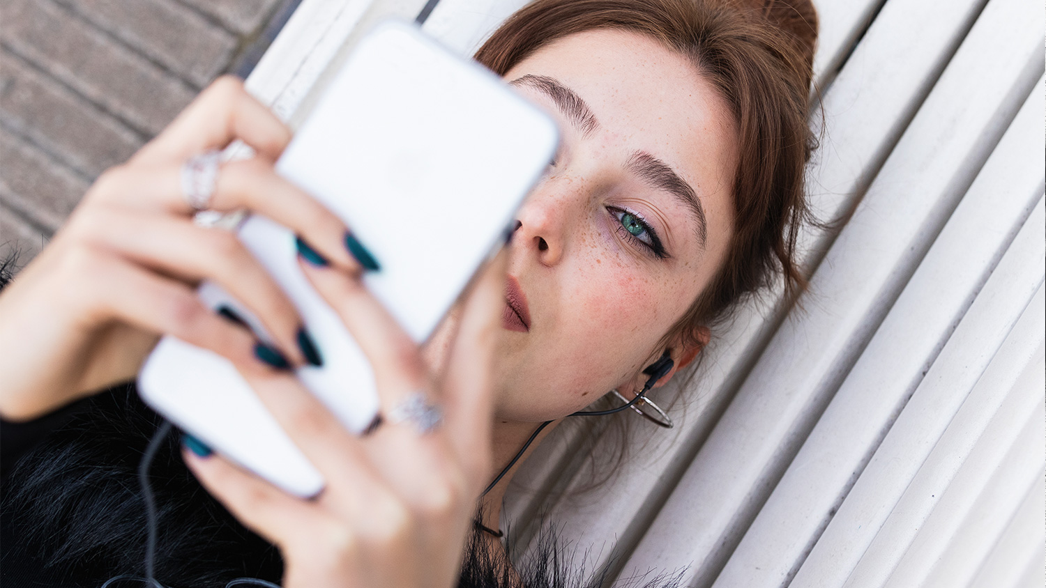 A woman laying down and looking at their cell phone