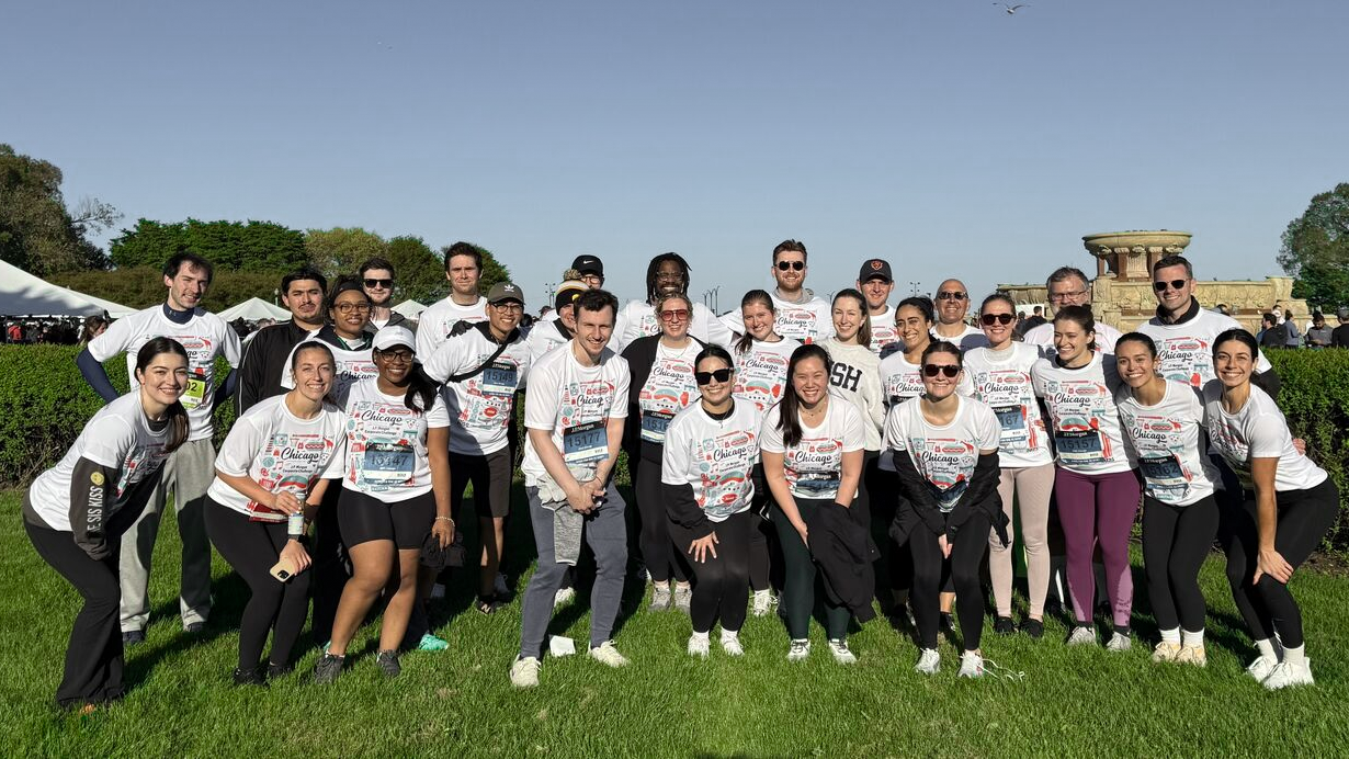 Group of coworkers dressed in matching shirts at an outdoor event.