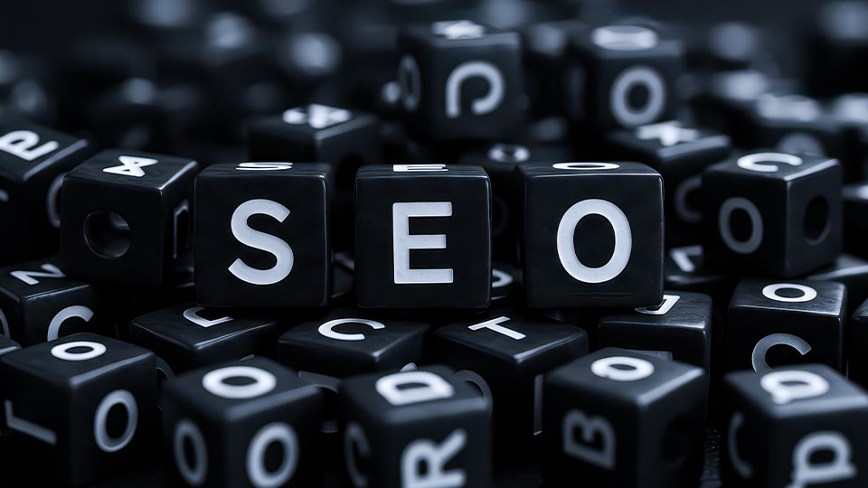 Several word cubes in a pile, with three cubes spelling "SEO" as the focus.