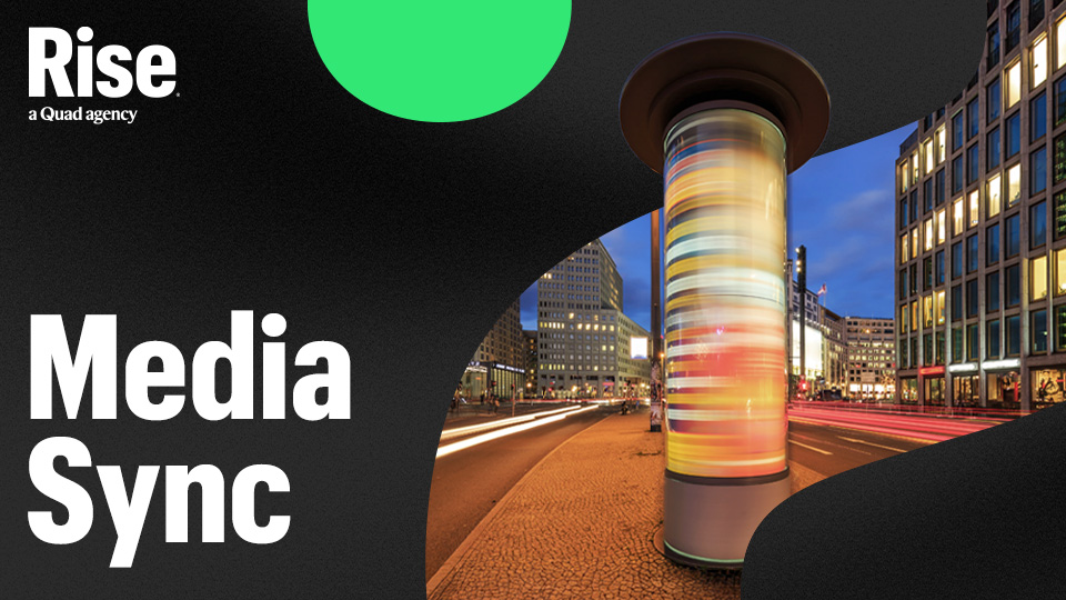 A long-exposure photo of a media billboard. Text reads: Media Sync