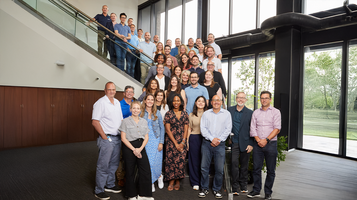 Rise's leadership team photographed on a staircase in the Quad HQ lobby.