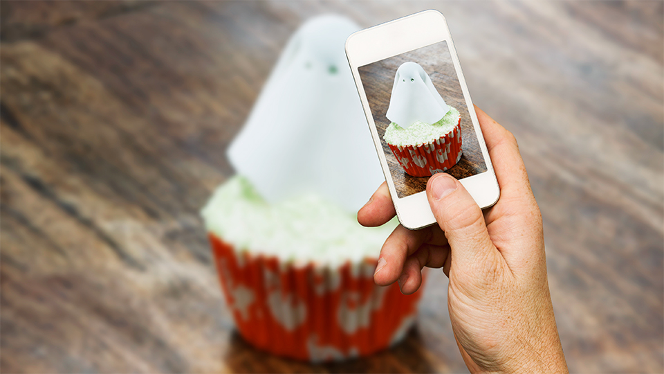 Someone taking a photo of a ghostly cupcake Someone taking a photo of a ghostly cupcake