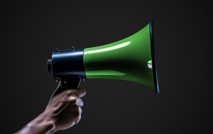 A green megaphone being held by a hand.