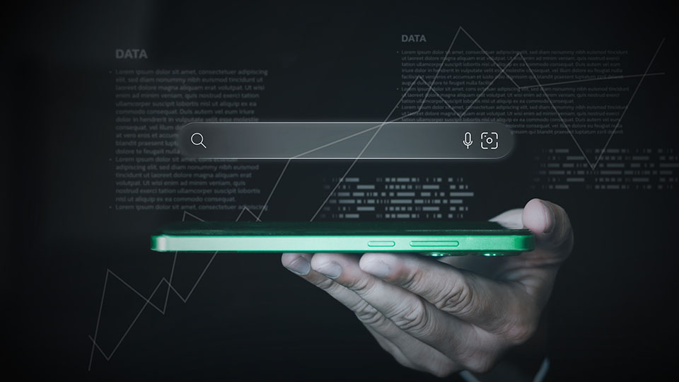 A search bar in dark mode hovering over a green cell phone being held in a person's hands. Data and information are spread throughout the image.