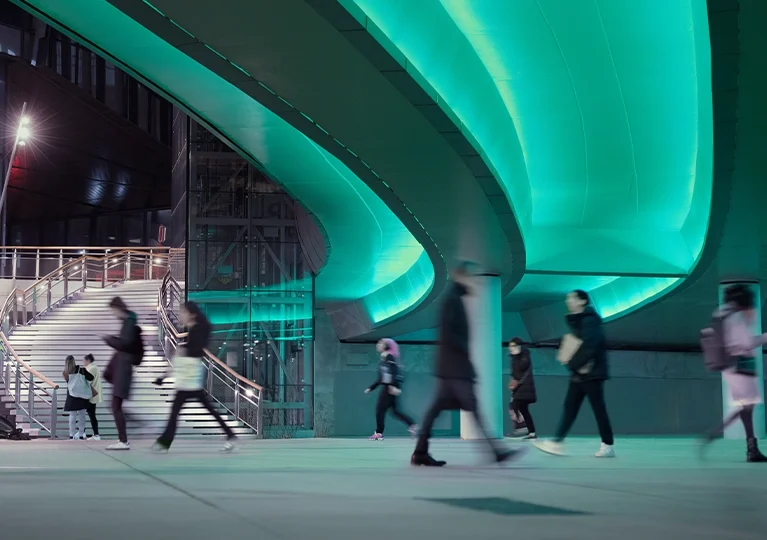 Busy travelers walking through an illuminated pathway