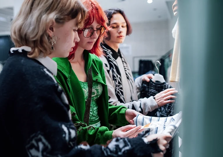 Young shoppers touching clothes in a store